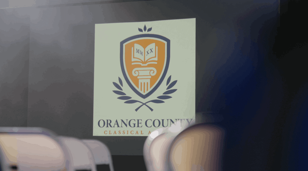 Orange County Classical Academy logo featuring a shield and laurel design.